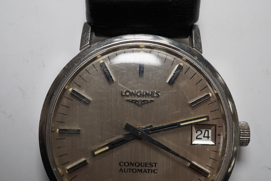 A gentleman's stainless steel Longines Conquest Automatic wrist watch, on an associated leather strap, case diameter 35mm. Condition - poor to fair